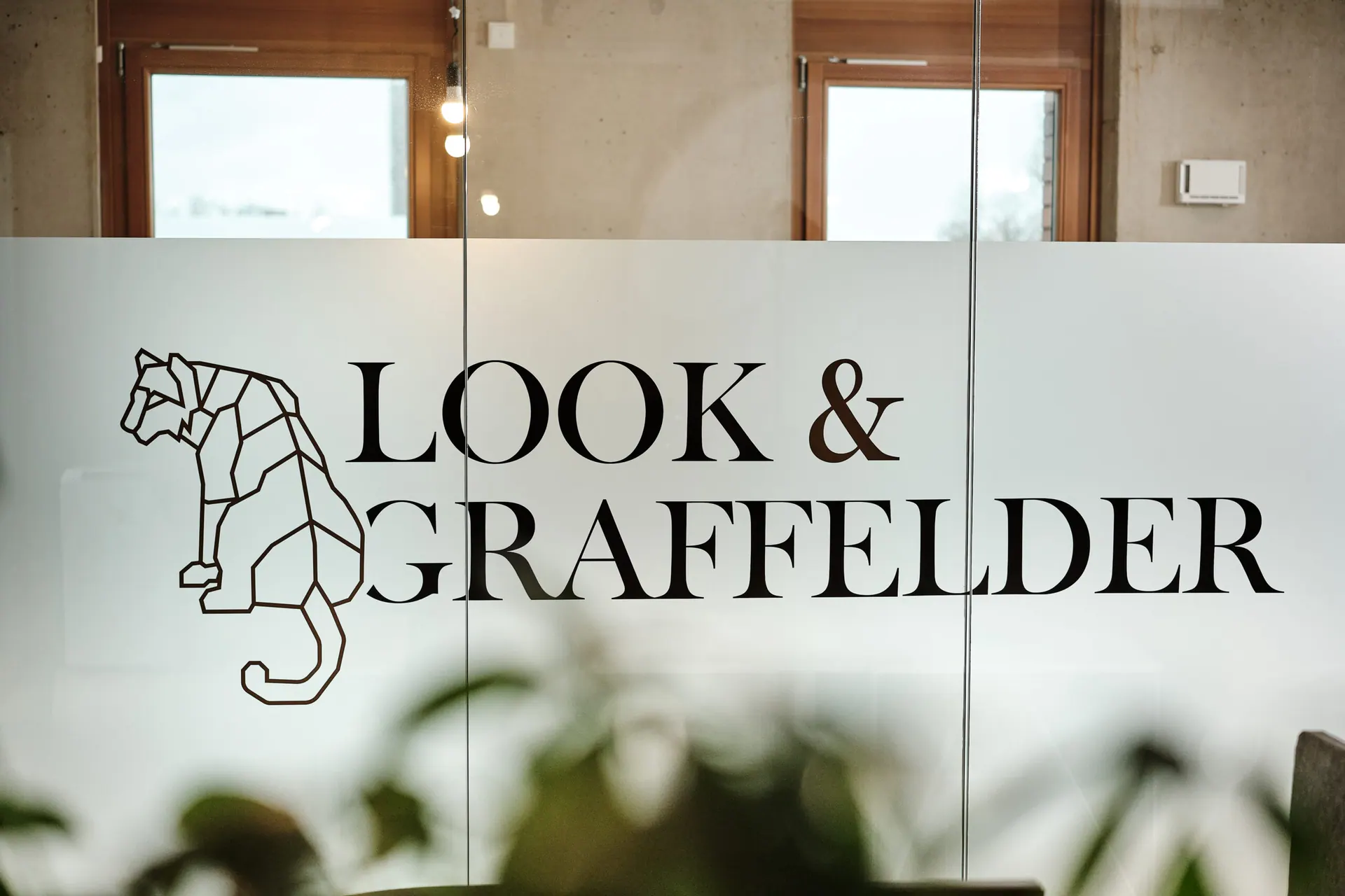 Look & Graffelder Glaswand mit Tiger-Logo — Personalberatung für Unternehmen aus Köln